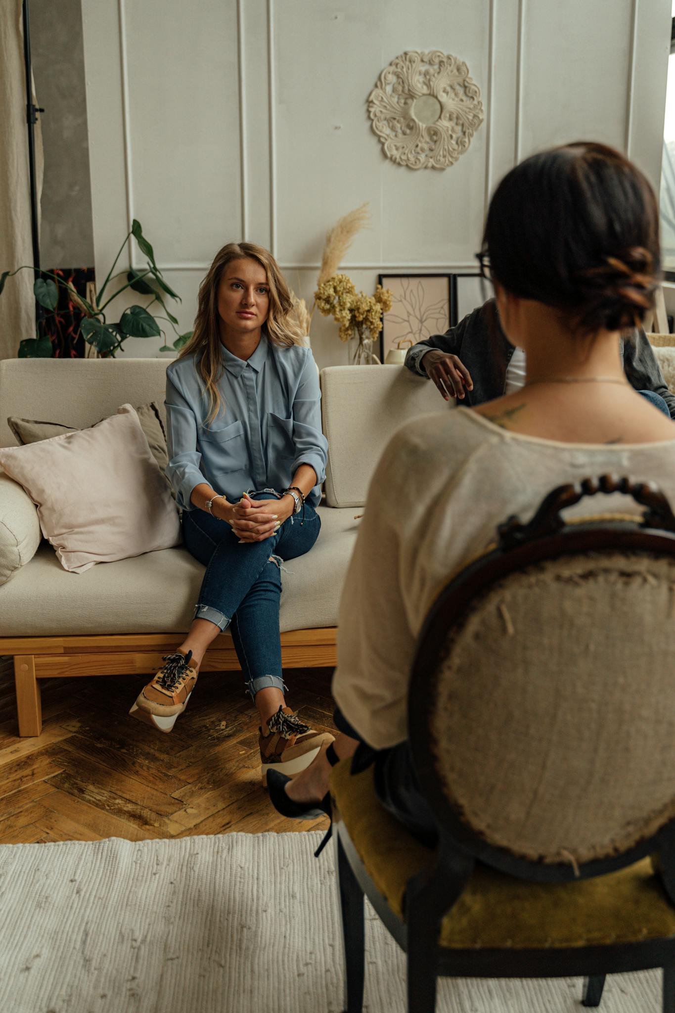 Woman in Blue Denim Jacket Sitting on White Couch